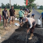 Forum Rogojampi Bersatu dan Laskar Bali Shanti Gelar Bakti Sosial, Perbaiki Jalan Rusak di Karangbendo