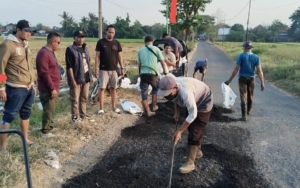 Forum Rogojampi Bersatu dan Laskar Bali Shanti Gelar Bakti Sosial, Perbaiki Jalan Rusak di Karangbendo